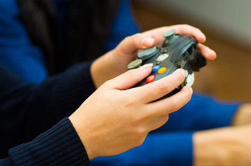 Close up hand holding a gamepad to play video games on the couch, concept about home entertainment, video games