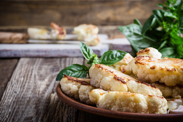 Roasted organic cauliflower steak on wooden board