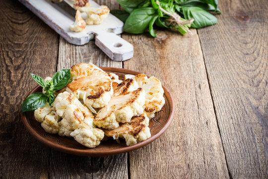 Roasted organic cauliflower steak on wooden board