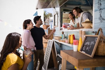 Smiling waiter taking order from couple