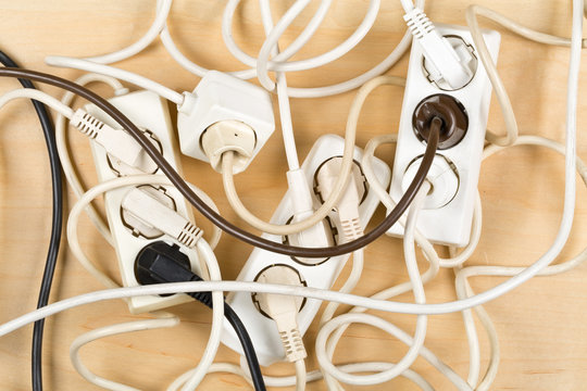 Cable chaos clutter from multiple electric wire extension cords and multi-contact plugs