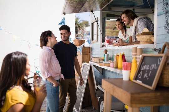 Couple interacting with each other at food truck van