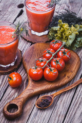 fresh tomato juice and Tomato branch on a wooden cutting board