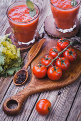 fresh tomato juice and Tomato branch on a wooden cutting board