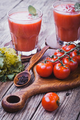 fresh tomato juice and Tomato branch on a wooden cutting board