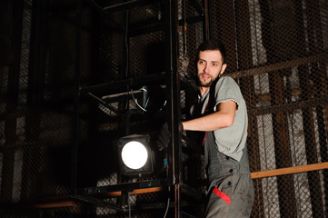 The lighting engineer adjusts the lights on stage behind the scenes