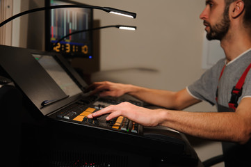 A lighting engineer works with lights technicians control on the concert show. Professional light...