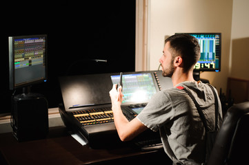 A lighting engineer works with lights technicians control on the concert show. Professional light...