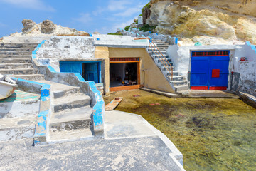 Colorful boat houses (sirmata) in Mandrakia village on the coast of Milos island, Cyclades, Greece. © vivoo