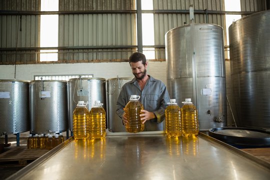 Worker examining a can of olive oil in factory