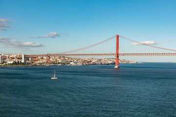 View of Lisbon, Portugal and the Abril 25 (April 25) suspension bridge in late afternoon light on a clear day with copy space