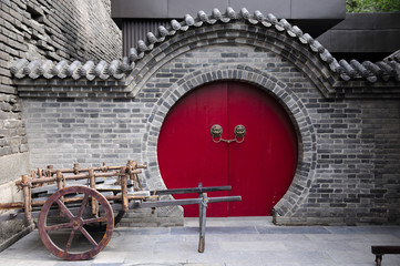 A wooden cart in front of a round door way at the south gate of the xian city wall in Shaanxi...