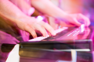 Musician plays keyboards in a rock band