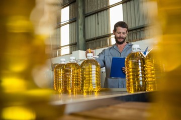 Worker writing on clipboard in olive factory