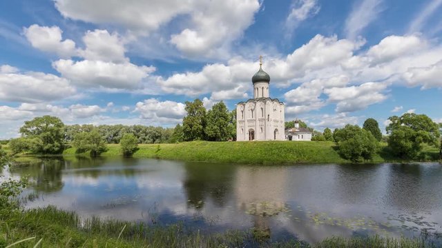 Church of the Intercession on the Nerl reflecting in water on sunny day with scenic clouds in Bogolubovo, Vladimir oblast, Russia
