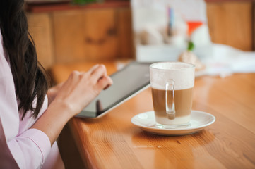 Close up hand woman using tablet in coffee shop
