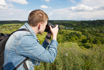 a young photographer photographing a landscape