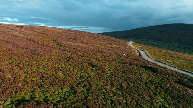 Drone view of irish turf or peat bogs and road. Wicklow Mountains, Ireland.Golden hours.4K footage.