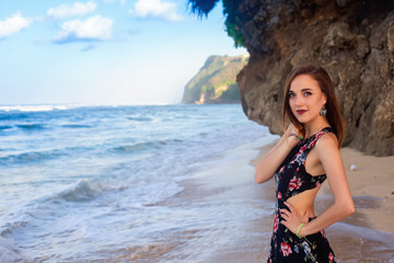 Fototapeta na wymiar Girls posing on the beach in front of the rock.