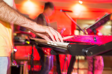 Musician plays keyboards in a rock band