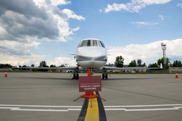 Private jet aircraft under guarding parked at the airport
