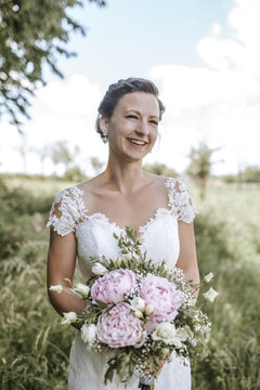 Beautiful bride smiling and holding bouquet