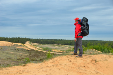 The tourist is looking around standing on the high dune. - 162770175
