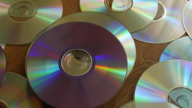 Optical Discs falling onto big pile of DVDs or CDs.