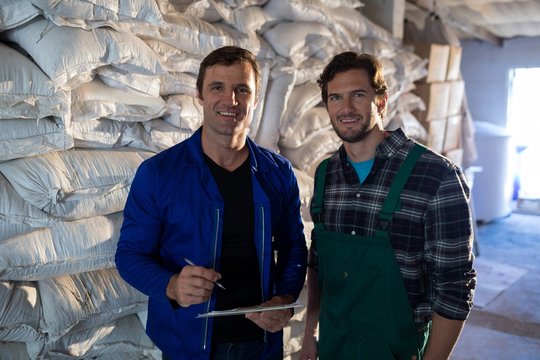 Portrait of coworkers standing by barley scaks