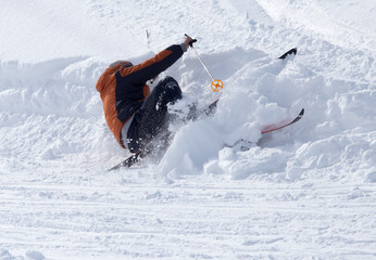 Naklejka premium The skier fell in the snow at speed