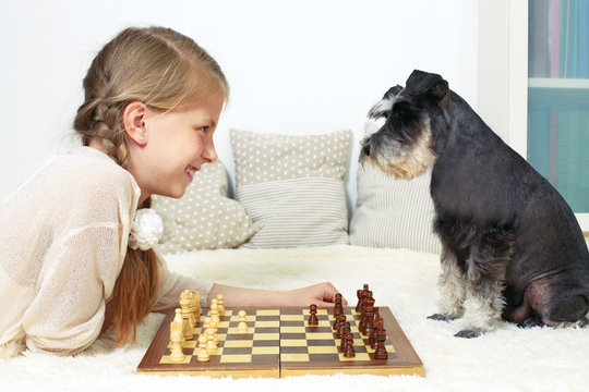 The dog teaches the child to play chess. Your move