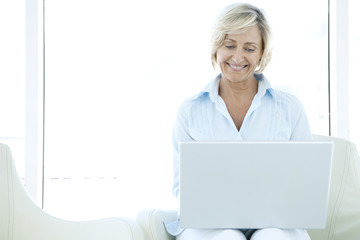 Happy Mature woman using computer 
