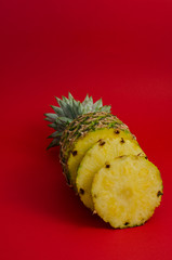 pineapple fruit on red background, circle slices - 162773173
