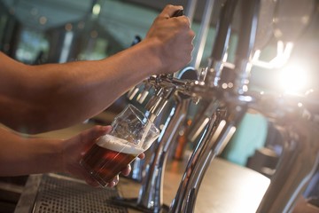 Bartender pouring beer from tap