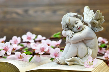Condolence card. Angel guardian sleeping on open book.