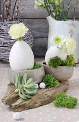 Floral arrangement with goose egg, carnations, chrysanthemum and moss.