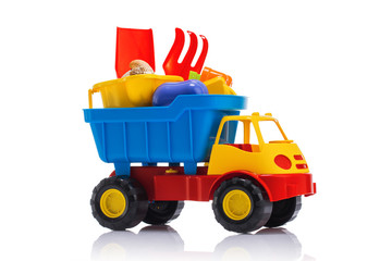 Baby beach sand toys and colorful plastic truck isolated