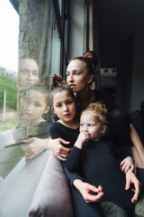 Mom and two daughters together at the window