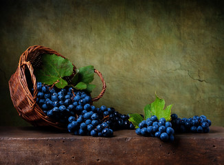 Naklejka na ściany i meble Still life with grapes on a basket