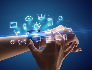 Hand wearing smartwatch with multimedia symbols