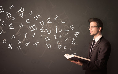 Young man holding book with letters