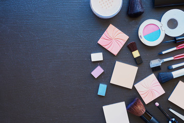 Women's accessories. Shadows, blush and powder on a black background.