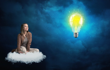 Fototapeta na wymiar Woman sitting on a cloud lokking at huge lightbulb