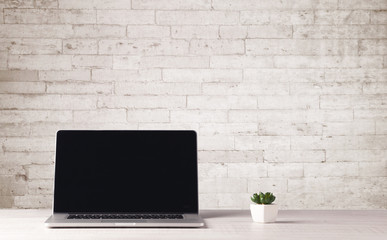 Naklejka na ściany i meble Business laptop with white brick wall