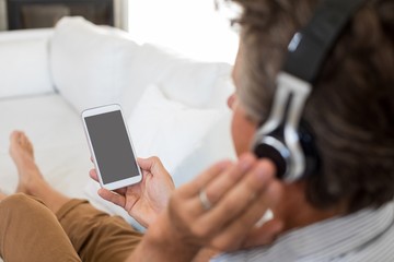 Man listening to music on headphones in living room