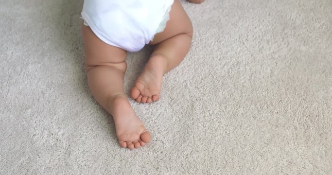 Baby Legs Crawling Away Above. shot from above of baby legs and diaper crawling on carpet in slow motion
