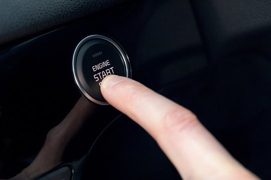 Cropped finger pressing car start button
