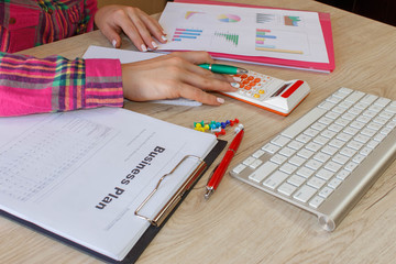 Female, taking notes, money and calculator on the table