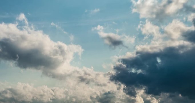 Time lapse clip of white fluffy curly rolling iridescent clouds