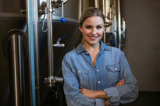 Portrait of smiling worker standing by storage tank